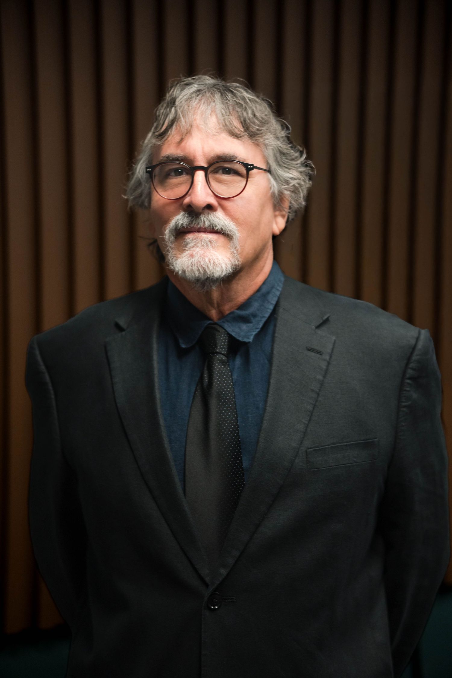 Professional portrait in a dark jacket and glasses